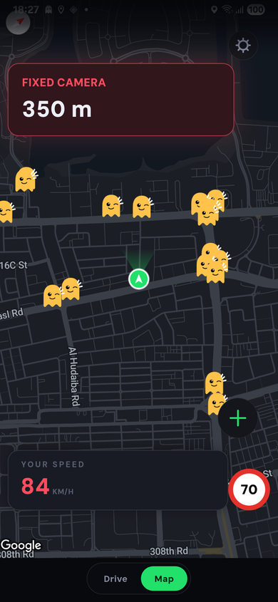 The Ghost map of central Dubai at night with many yellow ghost camera markers around the car. At 84 km/h against a limit of 70, the warning FIXED CAMERA 350 m at the top and the speed both turn red.